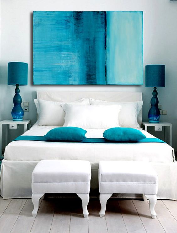 decoración del dormitorio en colores turquesa como un cuadro, los cojines y las lámparas de las mesillas