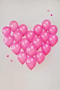 Decoración romántica para momentos especiales como san valentin o bodas con grlobos rosas formando un corazon