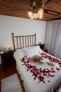 Decoración romántica para momentos especiales como san valentin o bodas clasico con la cama cubierta de petalos de rosas rojas