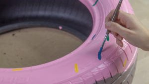 Pincel pintando virutas de colores en la cama donut