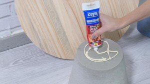 Aplicación de adhesivo de montaje para montar la mesa de cemento y madera