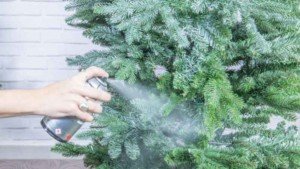 Pintura en spray adornando un árbol de Navidad