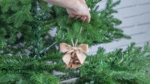 Colocación de una piña en el árbol de Navidad