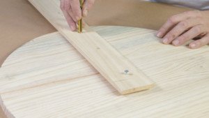 Lápiz trazando una base de madera en un tablero