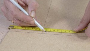 Marca con un lápiz sobre la madera al menos un centímetro inferior al tamaño del espejo