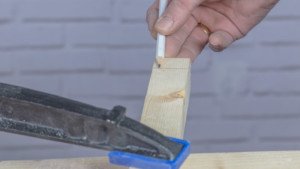 Lápiz marcando la madera para hacer la base de los colgadores