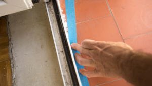 Colocación de cinta de carrocero para sellar las juntas de una ventana
