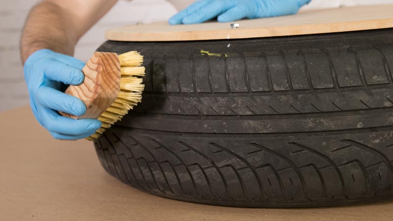 Cepillo limpiando el neumático que sirve de base para el asiento