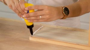 Aplicación cola blanca para unir las piezas del estante de madera