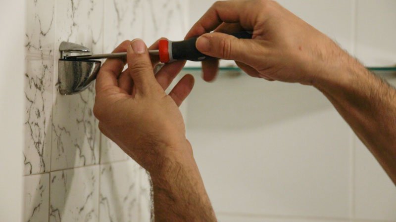 Retirada de los accesorios de la pared para pintar los azulejos del baño