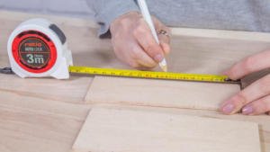 Medir las piezas de madera de la caja con el flexómetro