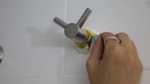 Retirada de la cinta de carrocero tras pintar los azulejos del baño