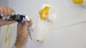 Aplicación de una segunda capa de esmalte sobre la pared de azulejos