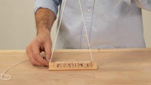 Colocar las cuerdas en el soporte para colgar el cartel de madera para la cocina.
