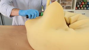 Cúter cortando la espuma sobrante del puff de trapillo