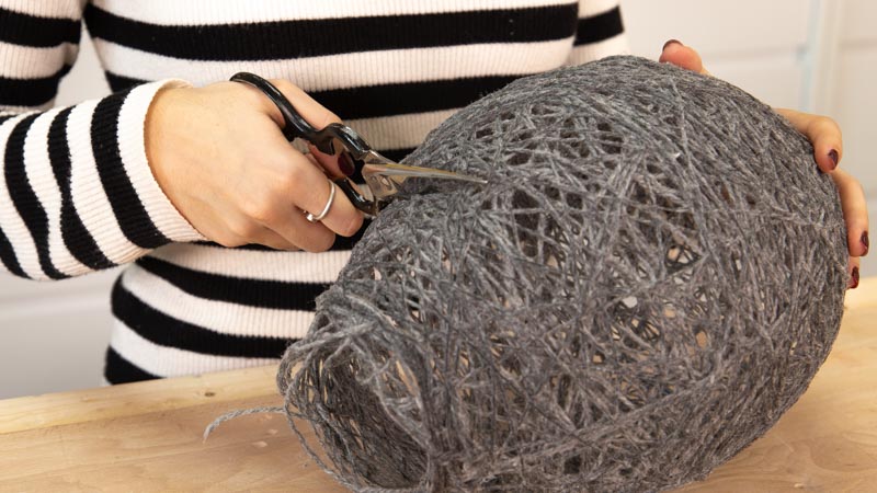Cortar la forma de la lámpara casera con hilo de lana.