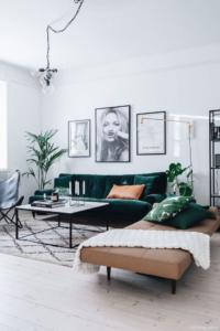 Salón de estar con colores neutros y sofá de color verde botella