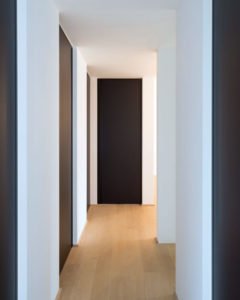 Decoración de pasillos con las paredes blancas y las puertas de color negro estilo minimalista