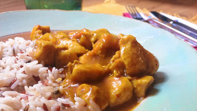 Detalle del pollo al curry con melocotón con arroz
