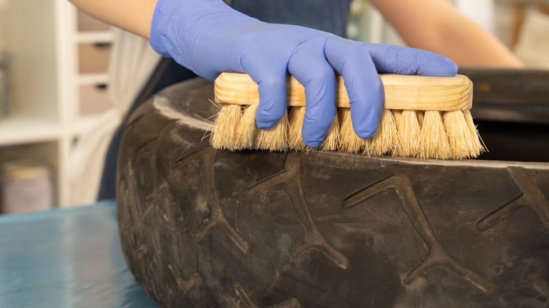 Cepillo limpiando la suciedad superficial de un neumático